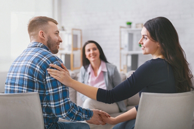 Couple sitting together in a therapy session, discussing their relationship with a counselor.