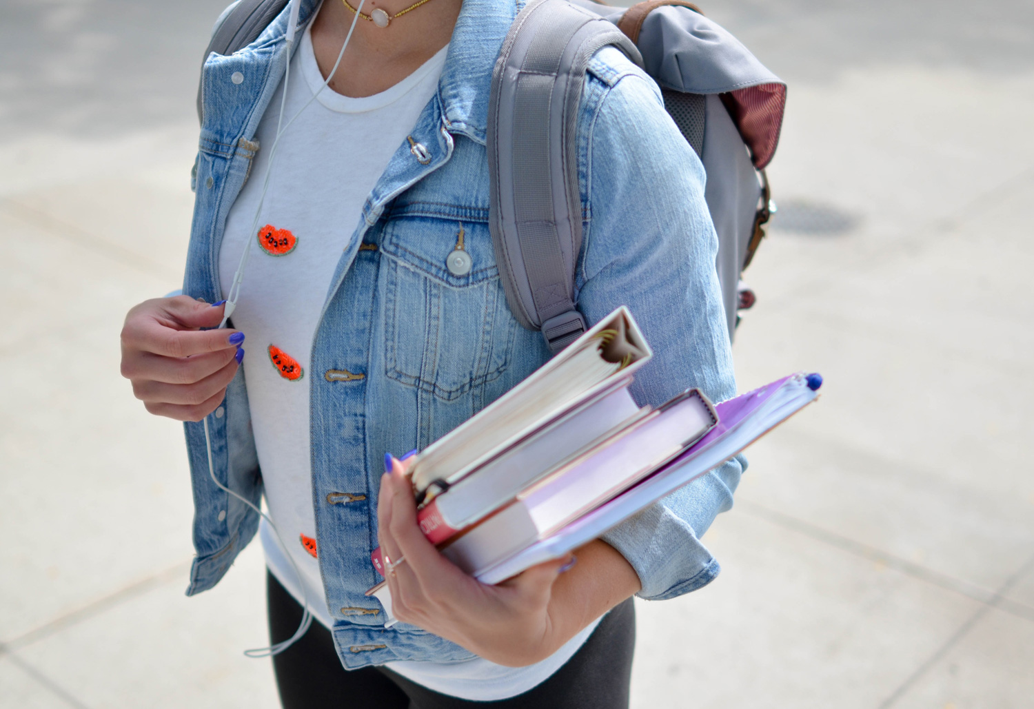 Student with a backpack and stack of books