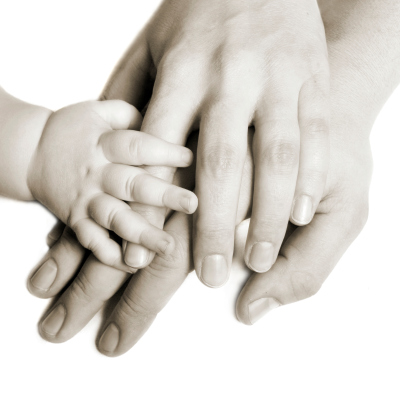 Man, woman, and baby hand on top of each other