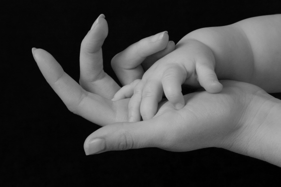 mother's hand holding baby's hand